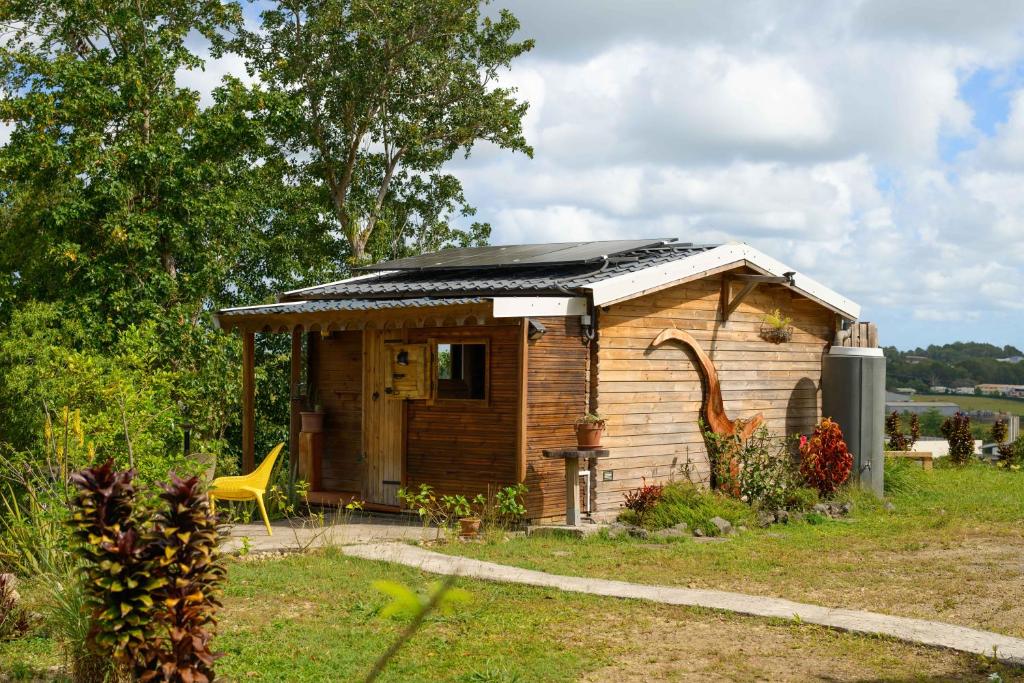a small shed with a roof on top of it at Le jardin de Védèze in Les Abymes