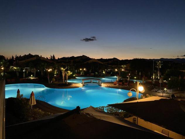 a large swimming pool at night with lights at Volpes home in Desenzano del Garda