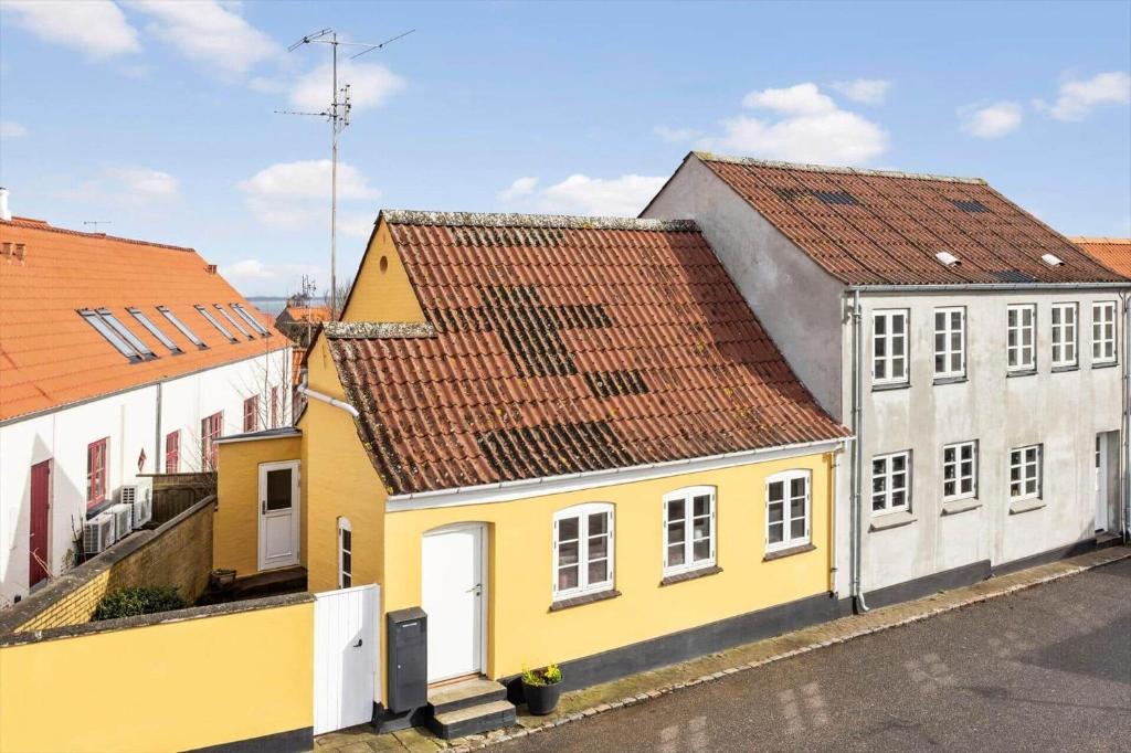 a row of yellow and white buildings on a street at AE324-Marstal-Kirkestraede-31 in Marstal