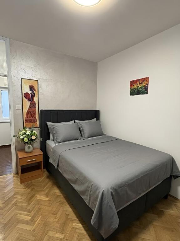 a bedroom with a large bed and a table at Apartman Katarina in Sutomore