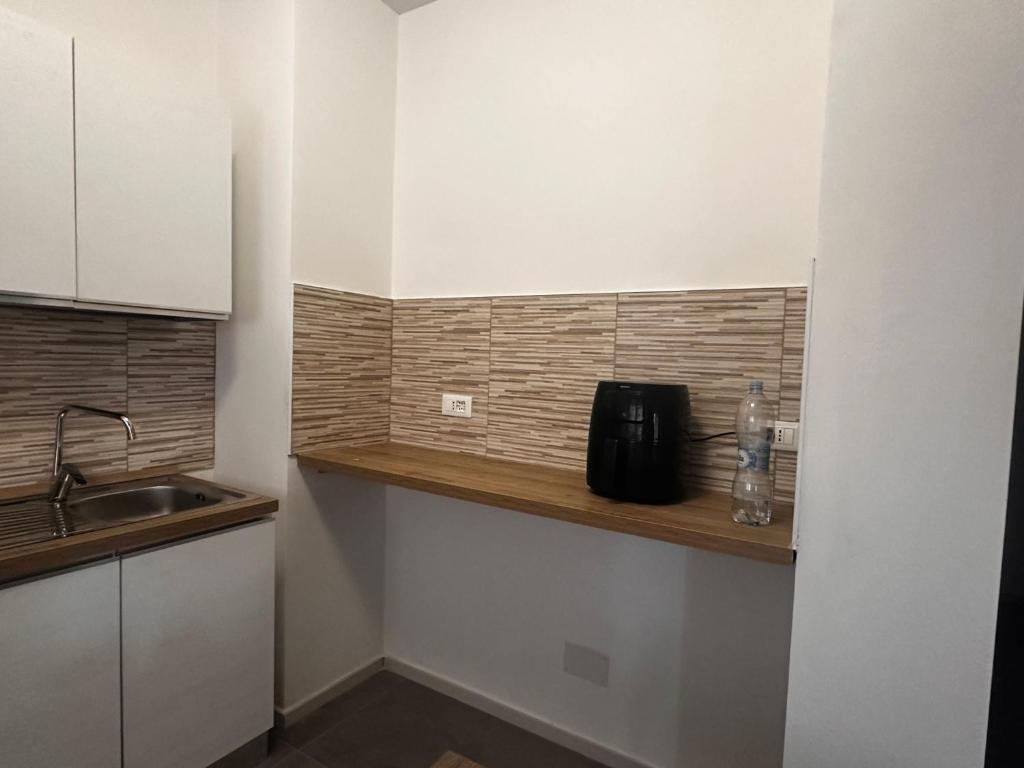 a kitchen with a sink and a bottle on a shelf at sweet rest in Castel Maggiore