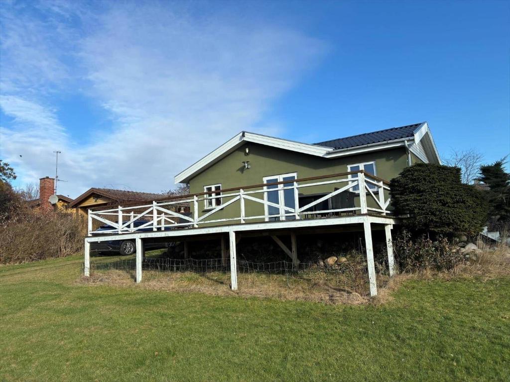 a house with a large deck on a grass field at FJ2403-Skibby-Hybenvaenget-27 in Skibby