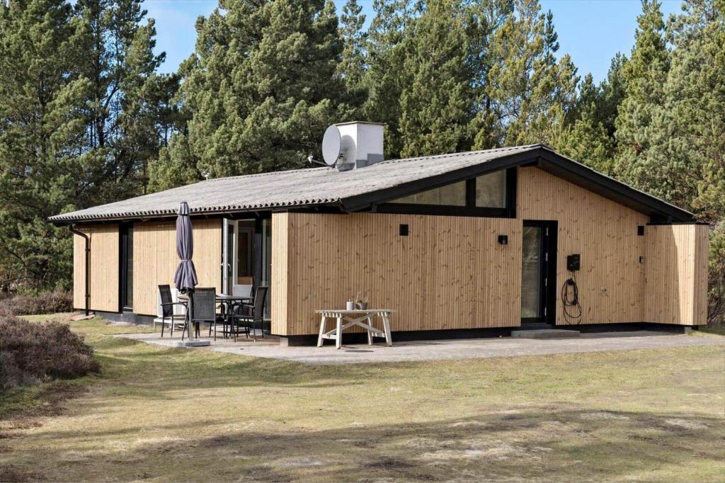 a large wooden building with a table and an umbrella at 2613-Romo-Sneppen-7 in Høm