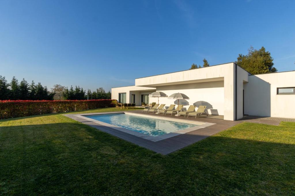 a house with a swimming pool in a yard at Casa Da Luz in Lousada