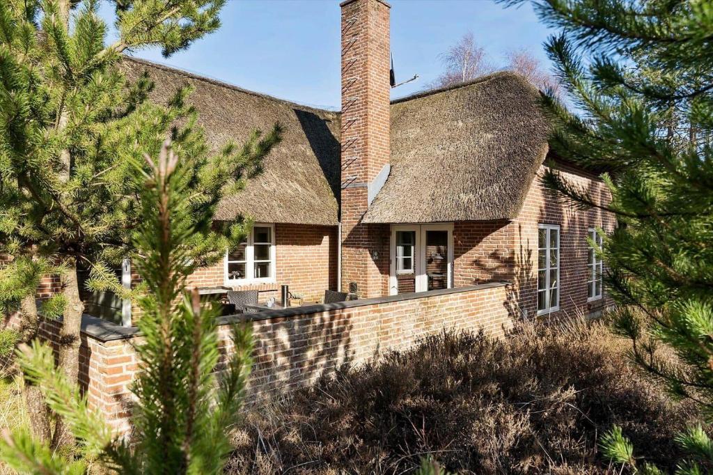 a brick house with a chimney and trees at 2010-Romo-Moritzvej-10 in Høm