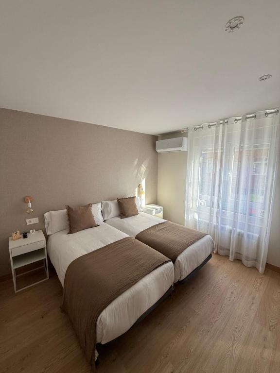 a bedroom with a large bed and a window at Pensión el Horno REFORMADO in León