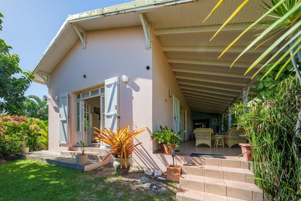 a house with a porch and a patio at Villa Providencia jacuzzi 1 min plage Le Diamant in Le Diamant