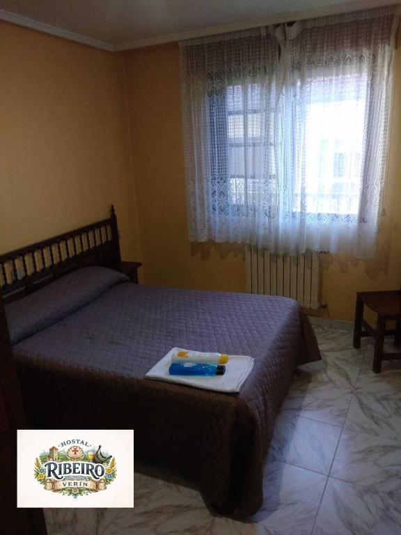 a bedroom with a bed with a tray on it at Hostal Ribeiro Verín in Verín