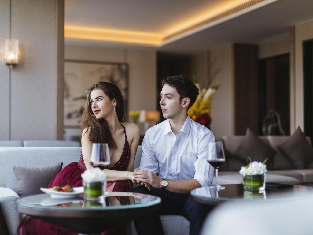 a man and a woman sitting at a table with wine glasses at Pullman Fuzhou Tahoe in Fuzhou