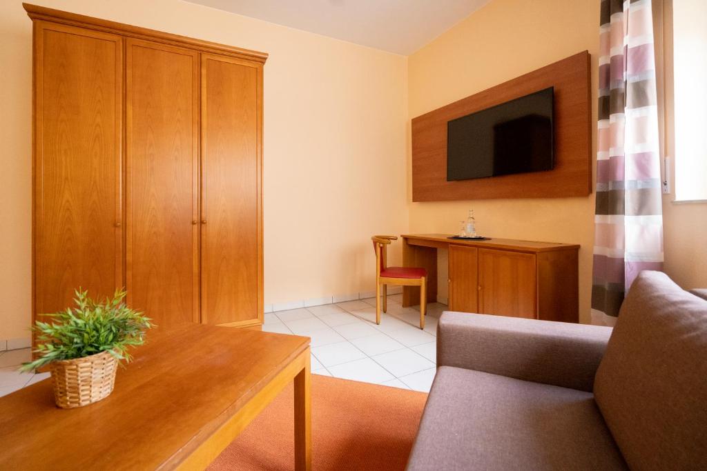 a living room with a couch and a tv at Hotel Nahetal in Gensingen