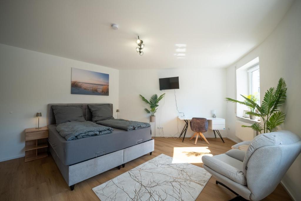 a living room with a bed and a chair at Helles Apartment in bester Lage in Landshut