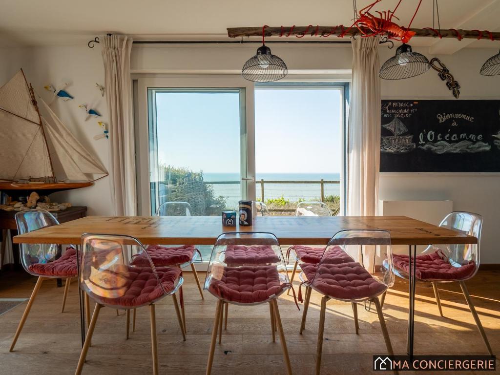 a dining room with a wooden table and chairs at L'océanne in Équihen-Plage