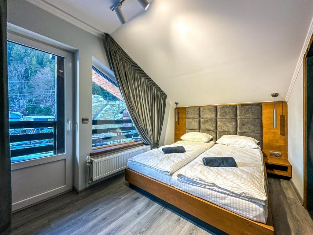 a bedroom with a large bed and a large window at Шале in Krivopolʼye