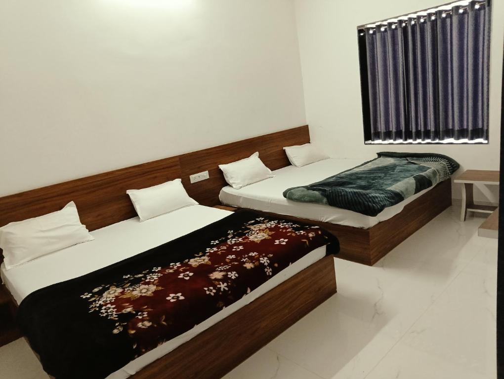 two beds sitting next to each other in a room at Shree Vishwakarma place in Khātu