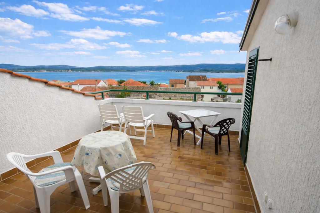 a balcony with a table and chairs and a view of the water at Apartments in Turanj 150 meters from the sea - By TA Leut Agency in Turanj