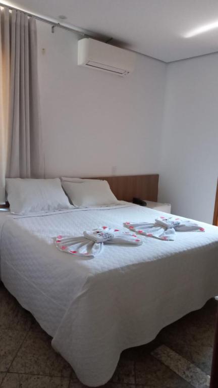 a white bed with christmas decorations on it at Hotel Pousada Bortolan in Poços de Caldas