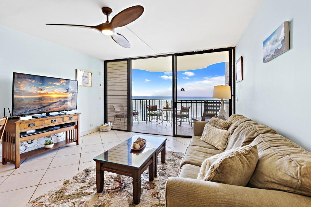 a living room with a couch and a flat screen tv at Kahana Reef 318 in Kahana
