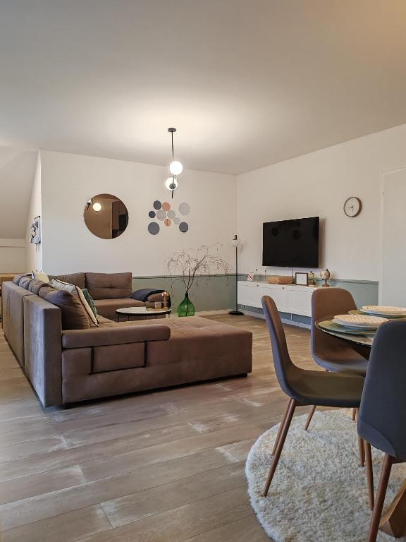 a living room with a brown couch and a table at U prolazu in Đakovo