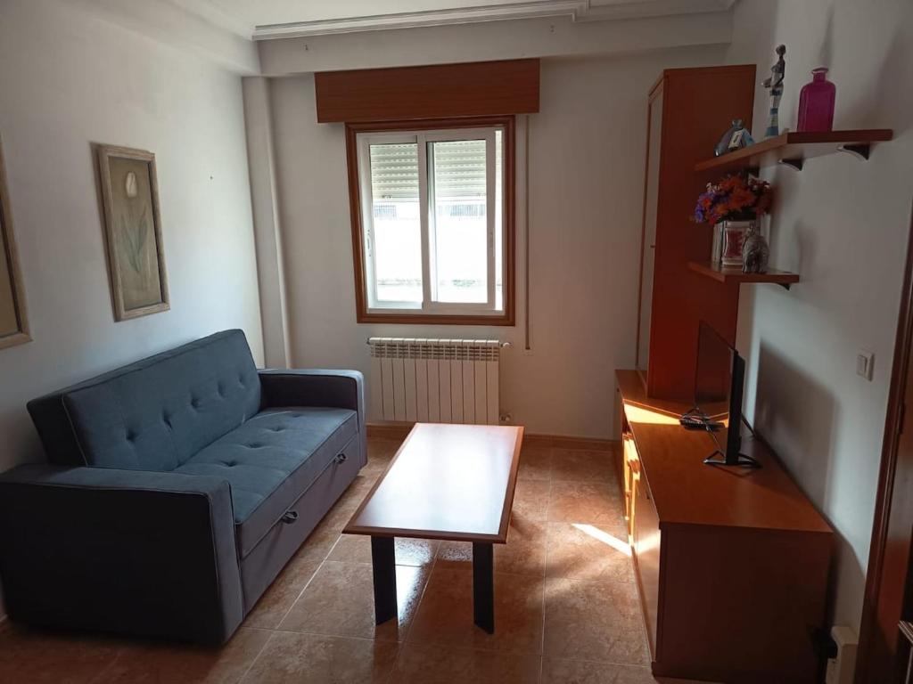 a living room with a blue couch and a coffee table at Casa en vigo in Vigo