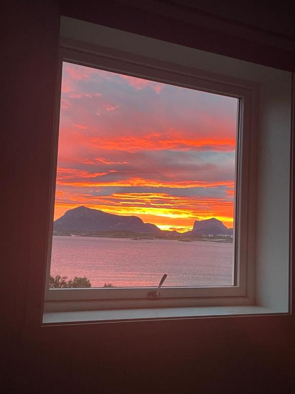 a window with a view of a sunset at Seaview Country House in Pettvik
