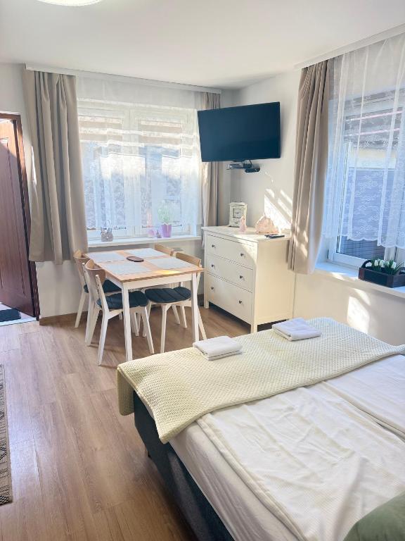 a bedroom with a bed and a desk and a table at Dom Gościnny Ania in Wisełka