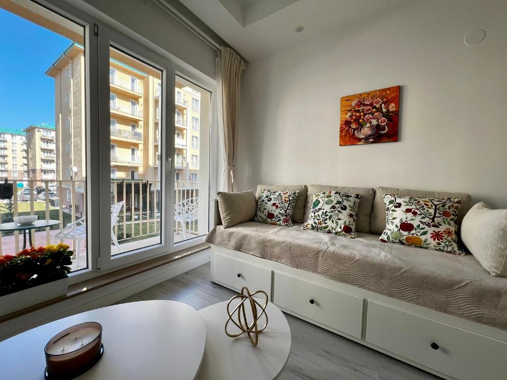 a living room with a couch and a large window at Kream Suite #Cosmopolis #Bucharest in Ştefăneştii de Sus