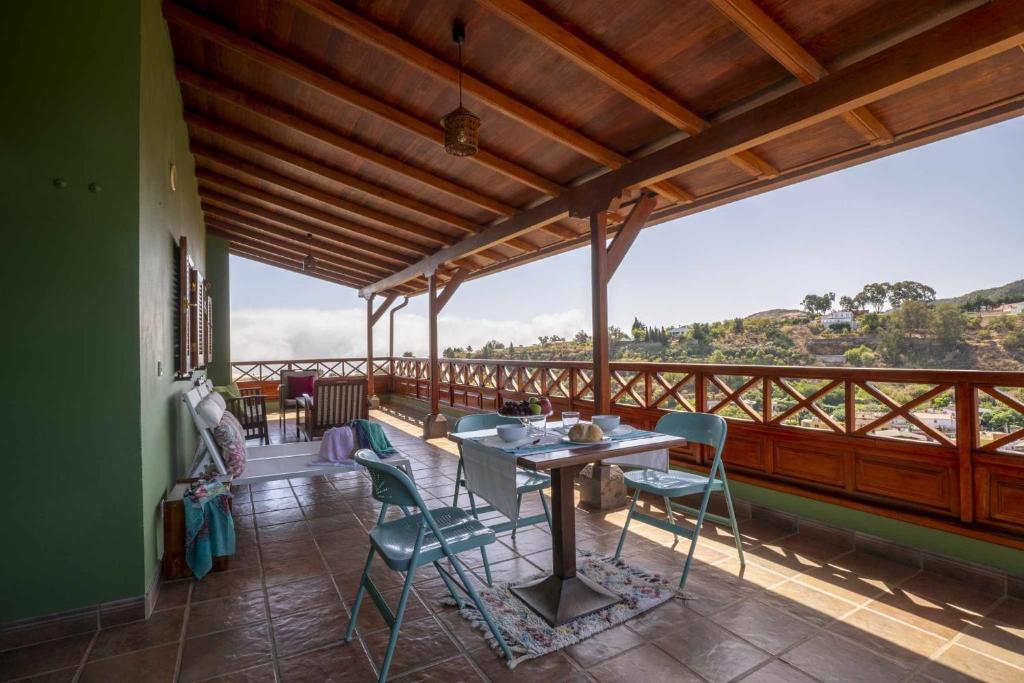 a dining room with a table and chairs on a balcony at El Cañaveral – Casa Rural con Terraza San Mateo in Vega de San Mateo