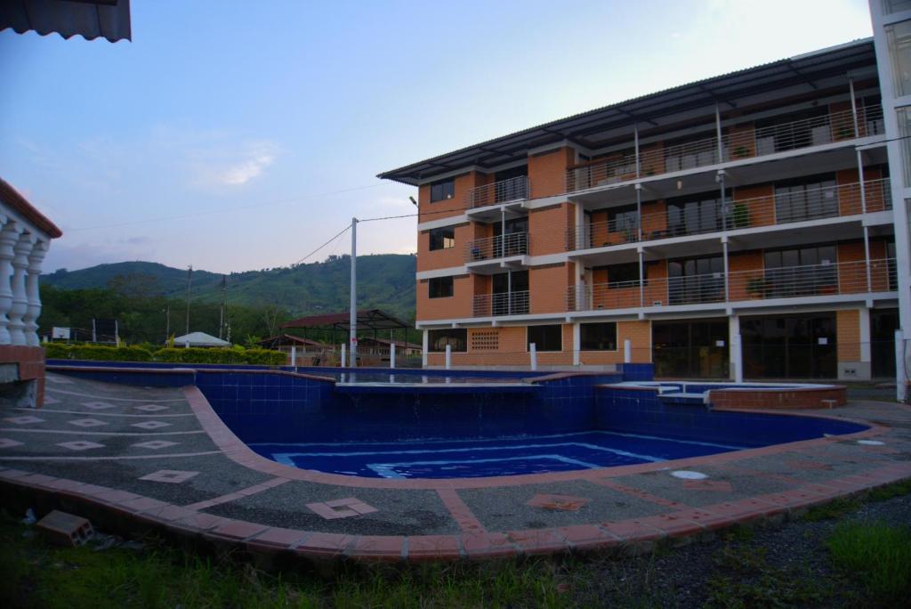a building with a swimming pool in front of a building at Palmeras 2 palestina caldas in Manizales