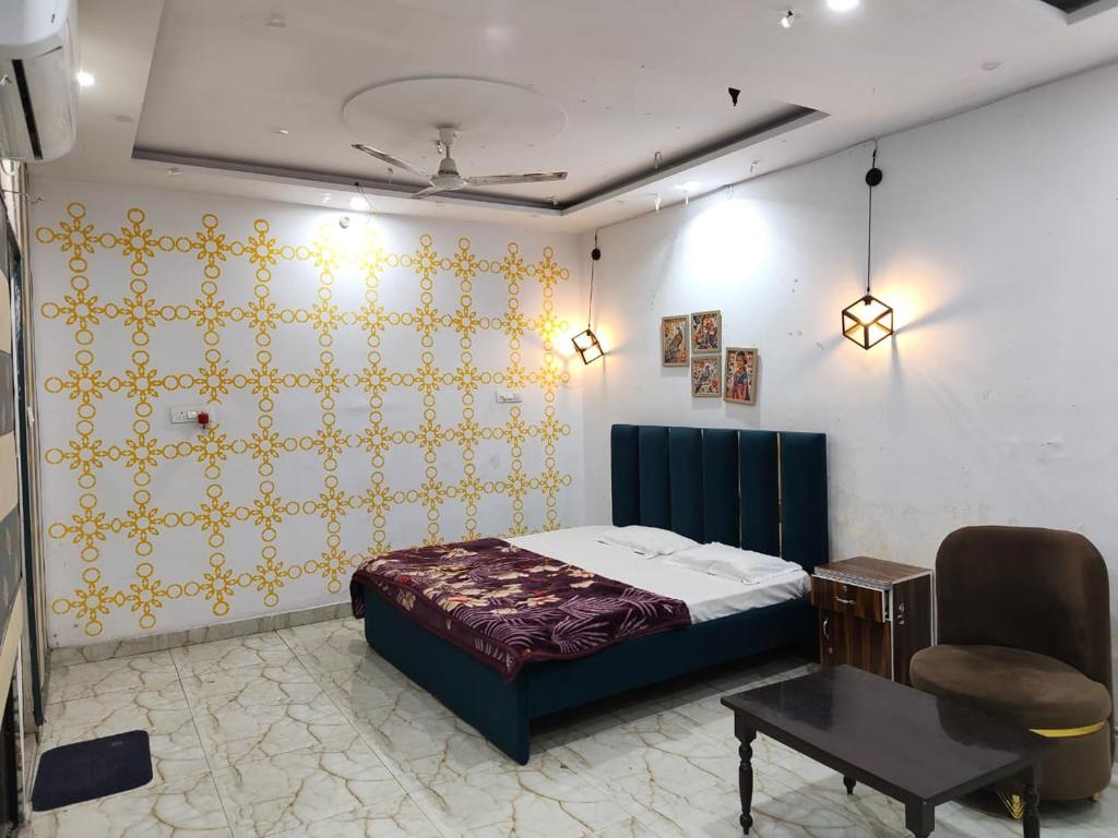 a bedroom with a bed and a chair and a table at The Moksha Residency in Prayagraj