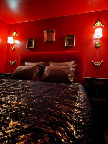 a red bedroom with a bed and two lamps at Nature, évasion, jacuzzi, grande piscine et cinéma in Houdancourt