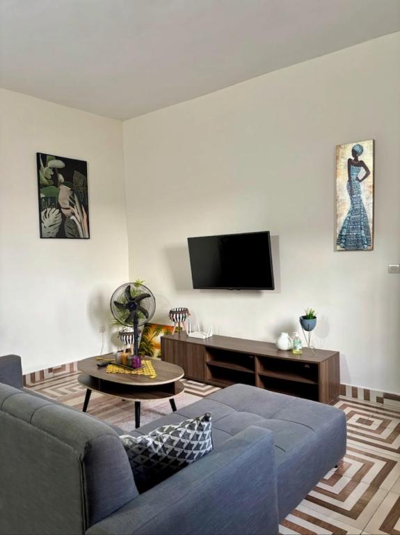 a living room with a couch and a tv at Synacassi 2 in Abidjan