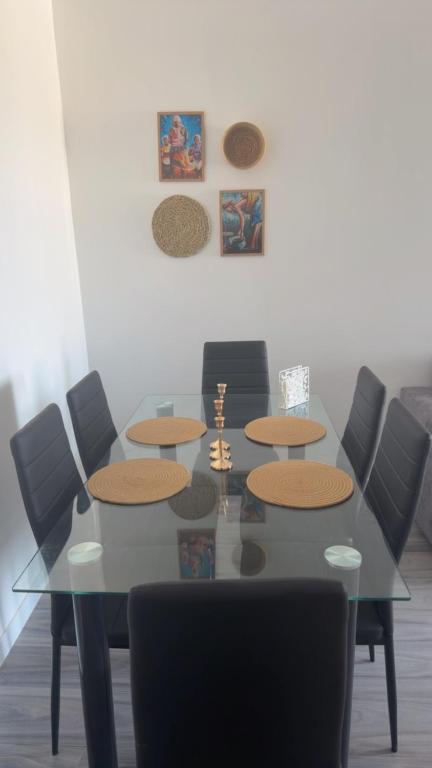 a dining room with a glass table and chairs at Ocean Palm Apartments II - Edifício Paradis- Cidadela in Praia