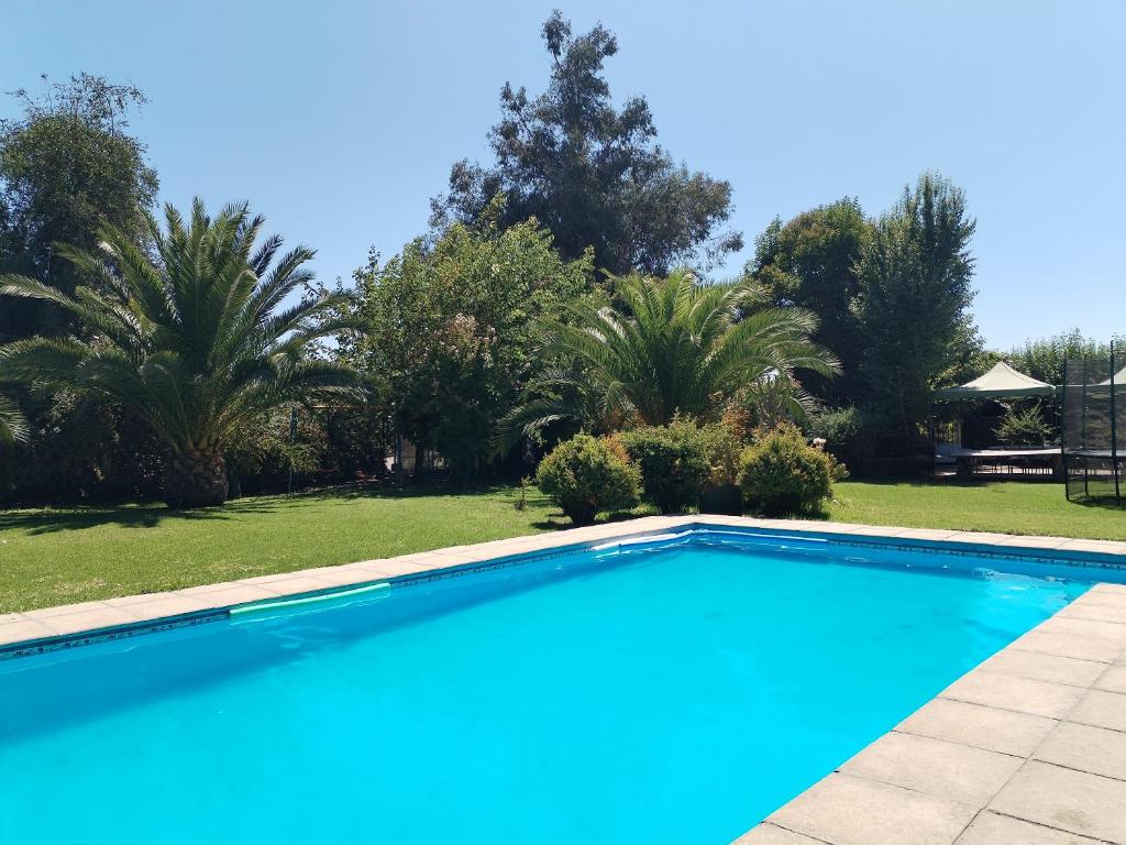 a swimming pool in a yard with palm trees at Casa Refugio Relajante in Pirque