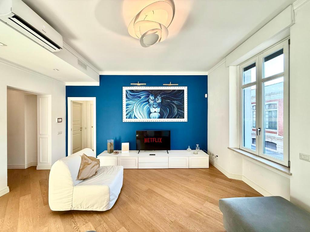 a living room with a white couch and a blue wall at La Casa Del Pittore - Centro Storico in Legnano