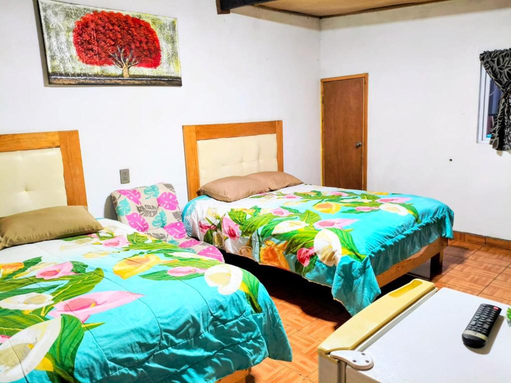 a room with two beds and a desk with a computer at CABAÑA tipo habitación con PALAPA y Asador Planta Alta en Zacatlán in Zacatlán