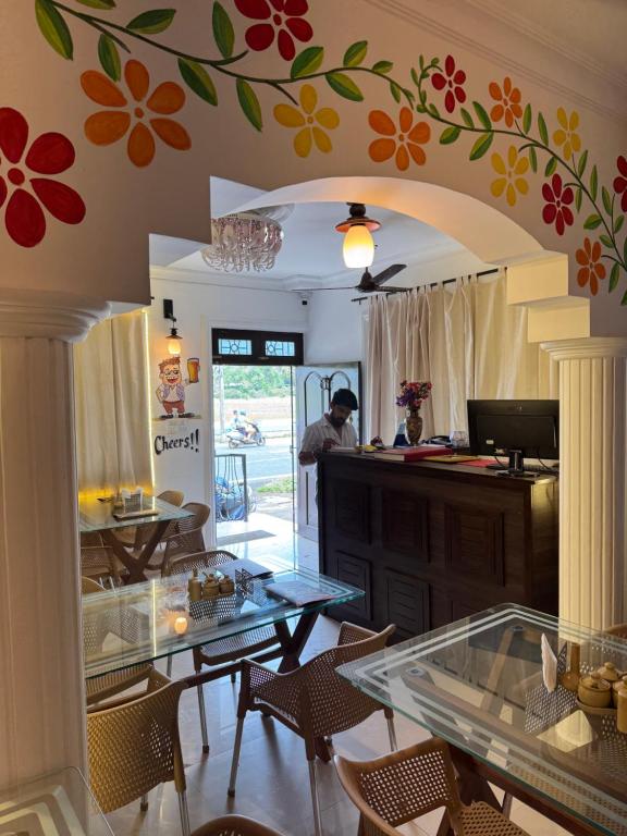 a dining room with a table and a flower mural on the wall at Paulina's Guest House in Madgaon