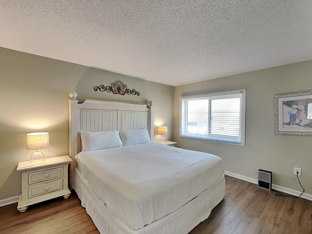 a bedroom with a large white bed and a window at Aqua Villa #101 in Fort Walton Beach