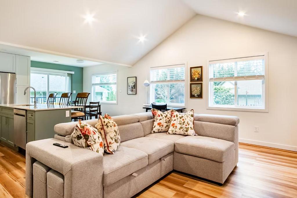 a living room with a couch and a kitchen at Harbourview Hideaway Sooke in Sooke