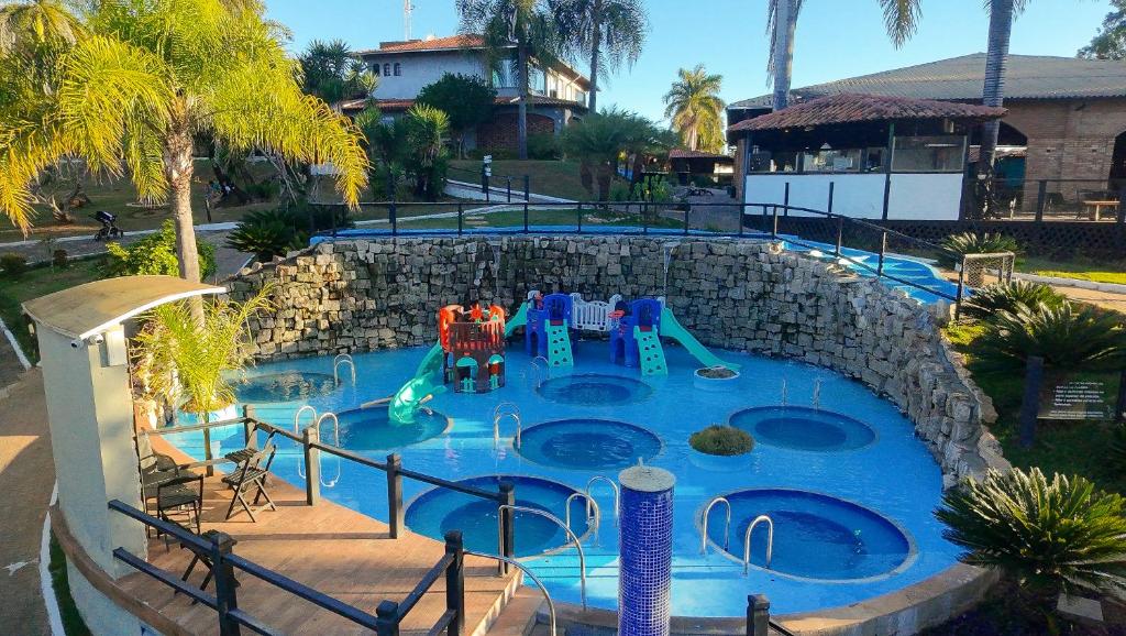a swimming pool with a playground in a resort at Village Resort All Fun Inclusive in Jaboticatubas