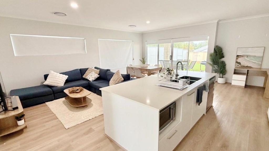 a living room with a blue couch and a kitchen at Eagle Breeze in Eaton