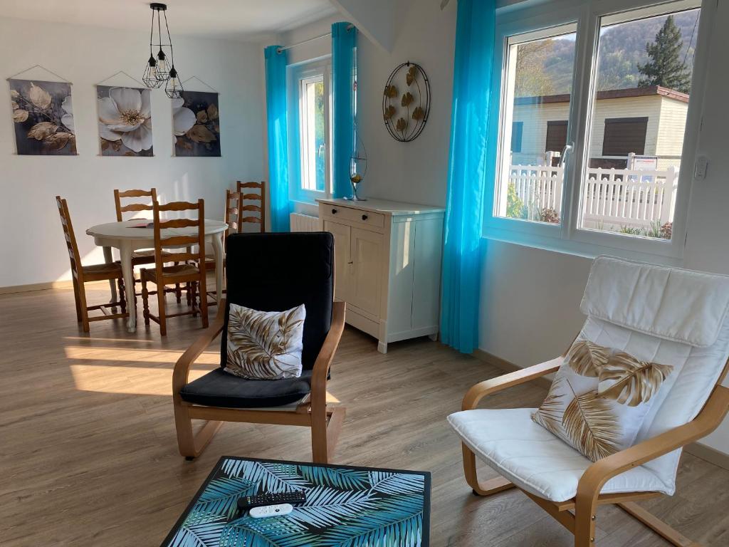 a living room with chairs and a table and a dining room at Le rendez-vous des 2 amants in Romilly-sur-Andelle