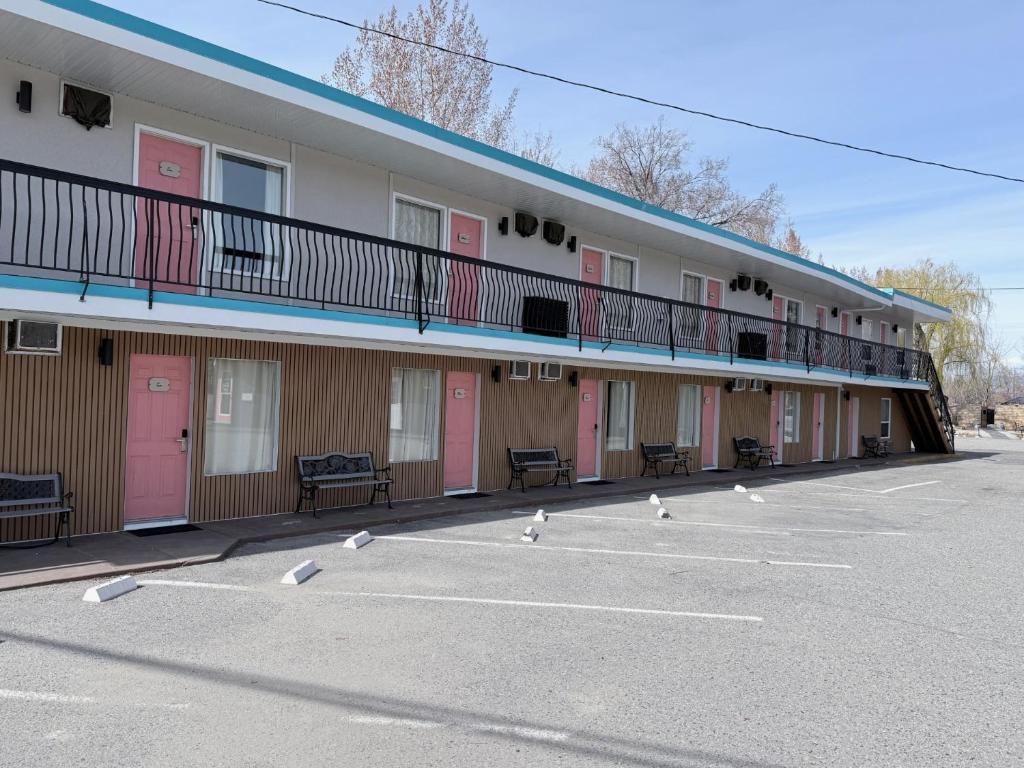 a row of buildings with pink doors and birds in the parking lot at Lakeside Villa & Nordic Spa in Penticton