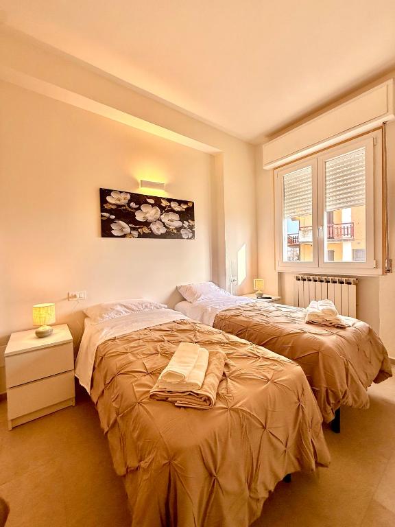 a bedroom with two beds and a window at B&B Il COTOGNO - Cucina e Parcheggio Privato in Serramazzoni