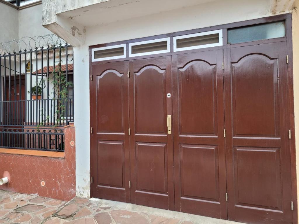 a pair of brown garage doors in front of a building at Tia Clara in San Salvador de Jujuy