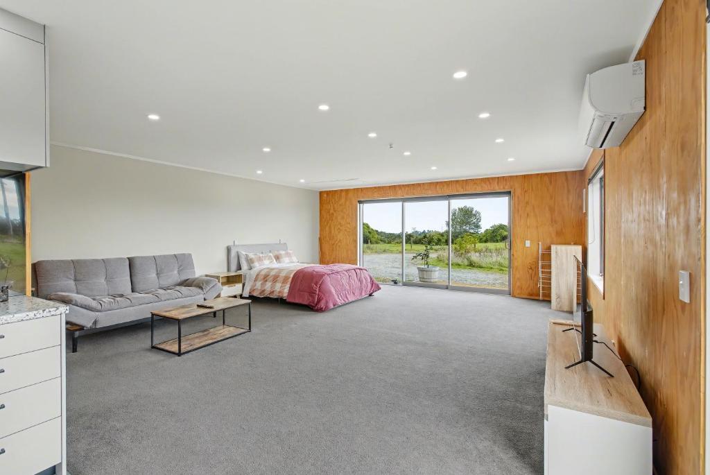 a living room with a bed and a couch at The Little Hive in Westport