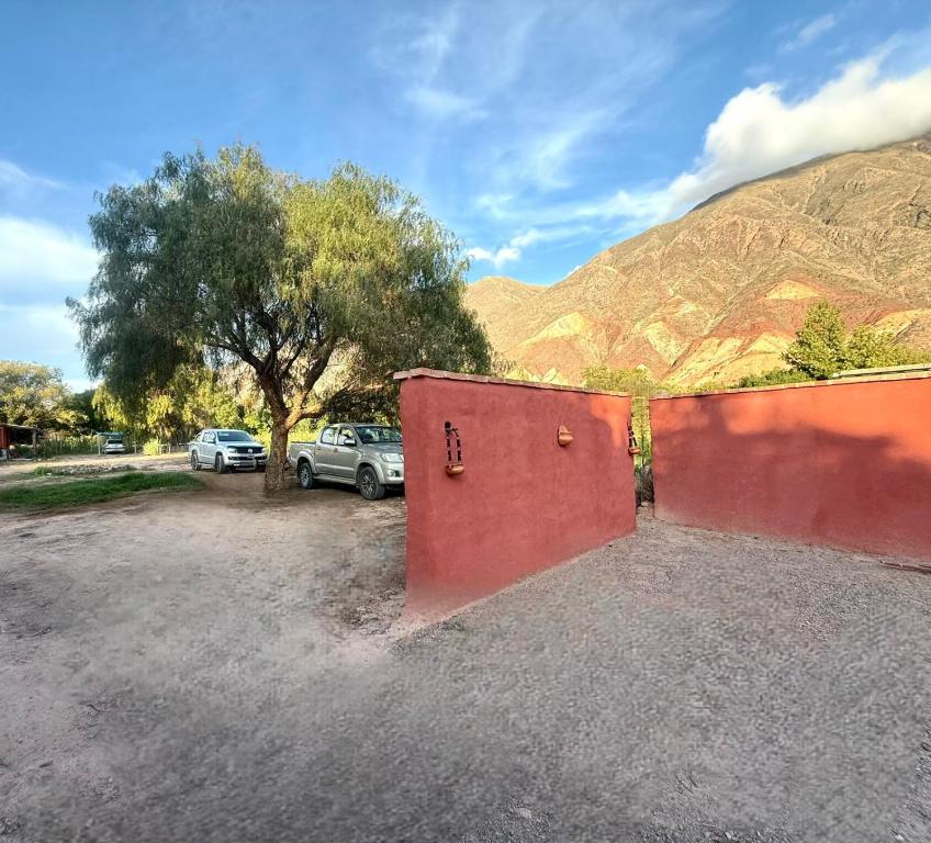 a red garage with a car parked in front of a mountain at Cabañas El Cardón in Maimará