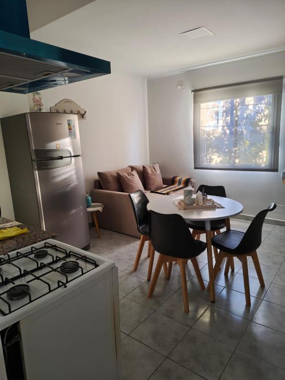 a kitchen with a stove and a table with chairs at Quimey Ruca Alojamientos in Neuquén