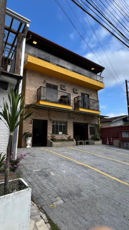 a large brick building with a balcony on a street at Pousada Mar de Ubatuba - Itaguá in Ubatuba