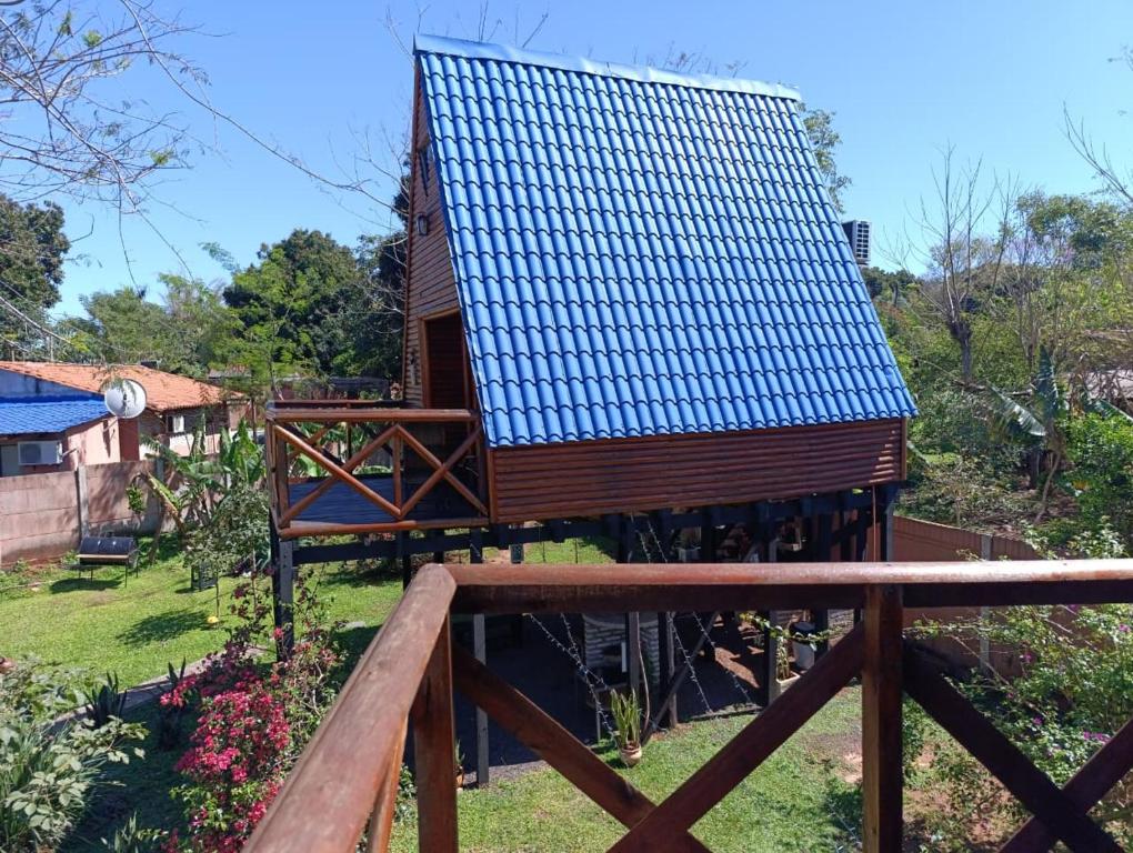 a small house with a blue roof on a yard at Posada Turística Alpinas Kamba in Paraguarí