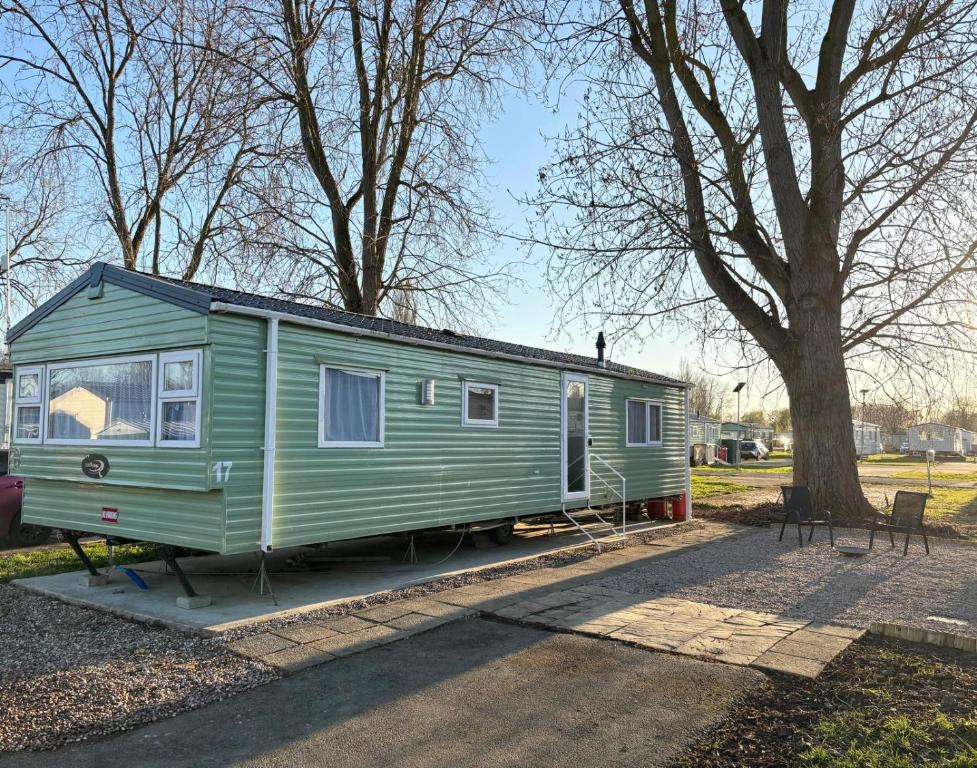 a green trailer parked next to a tree at The Getaway Billing Aquadrome in Great Billing